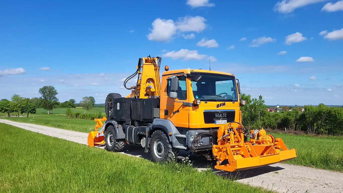 Fuhrpark-Fahrzeug mit Anbaugerät auf dem Feldweg